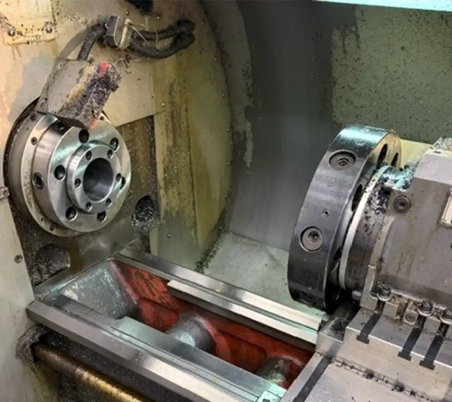 Close-up of the chuck and automatic tool changer inside the machining area of the STYLE 510 CNC lathe Záber zblízka na upínacie skľučidlo a automatický menič nástrojov vo vnútri obrobovej zóny CNC sústruhu STYLE 510